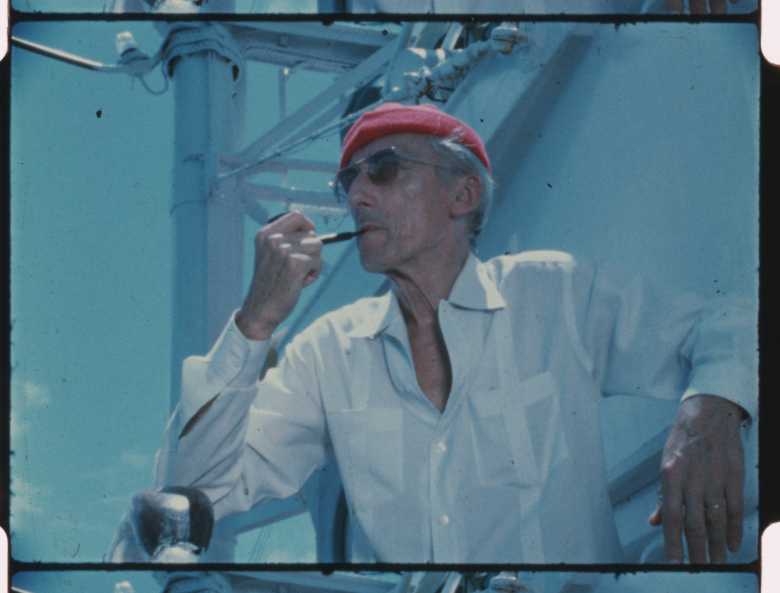 Jacques Cousteau lleva su icónica gorra de buceo roja a bordo de su barco Calypso, alrededor de la década de 1970.  (Crédito: La Sociedad Cousteau)