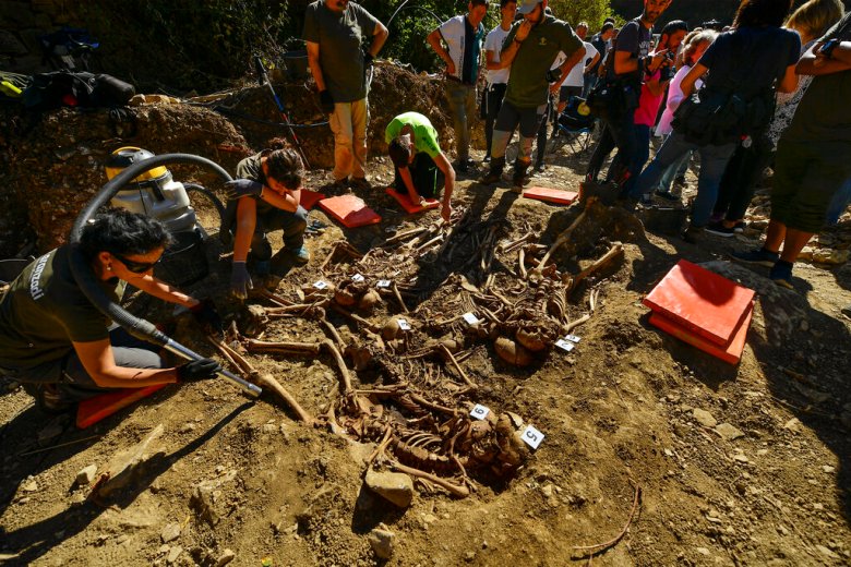 Archeologists inspect a grave in the small village of Ollacarizqueta, around 18 km (11, 18 miles) from Pamplona, northern Spain, Monday, Sept. 30, 2019. Archeologists have found a grave site in Ollacarizqueta containing what they believe to be the remains of sixteen republican prisoners killed during the Spanish Civil War. (AP Photo/Alvaro Barrientos)